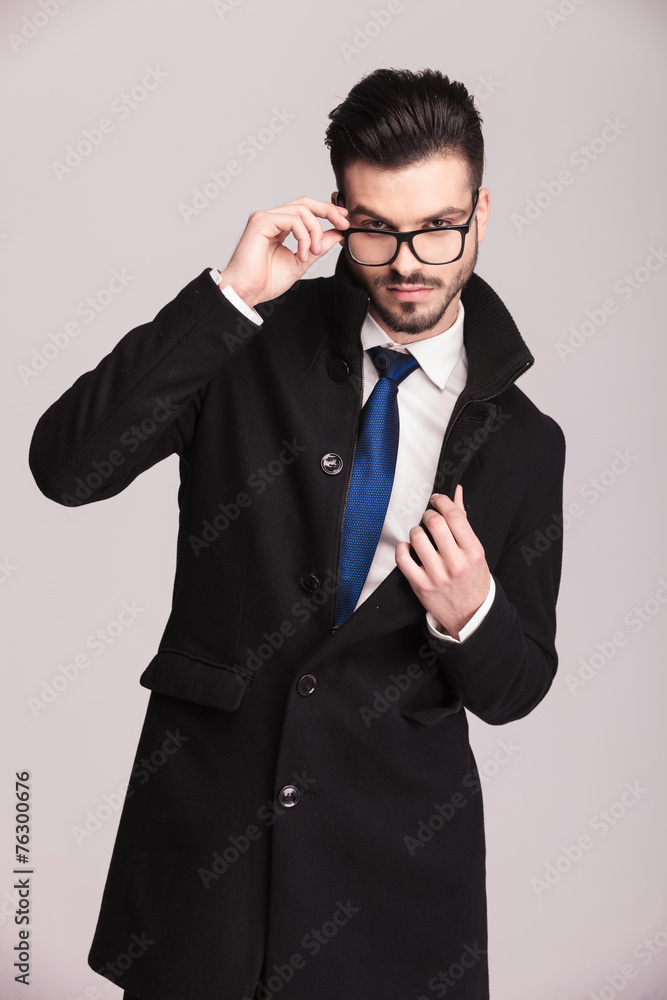 young elegant business man fixing his glasses young elegant business man fixing his glasses