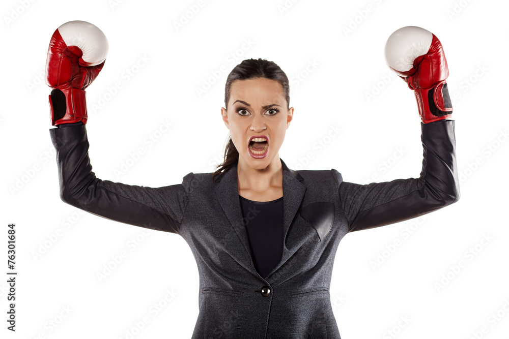 Angry business woman with boxing gloves in winning position Angry business woman with boxing gloves in winning position