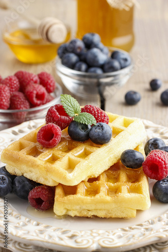 Waffles with syrup raspberries and blueberries