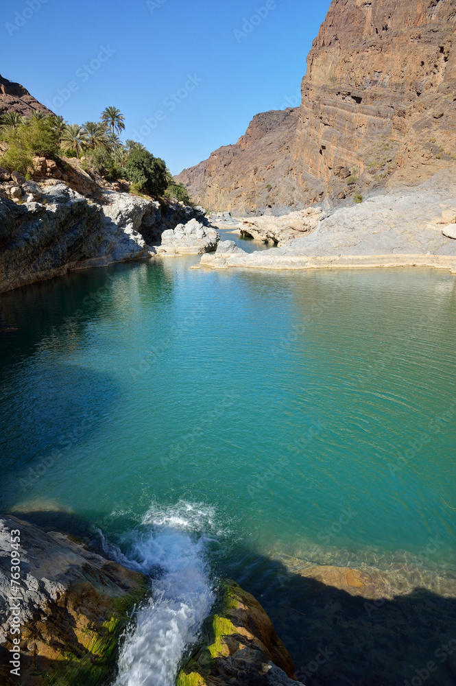 Water flowing to the natural pool between the mountains in Oman