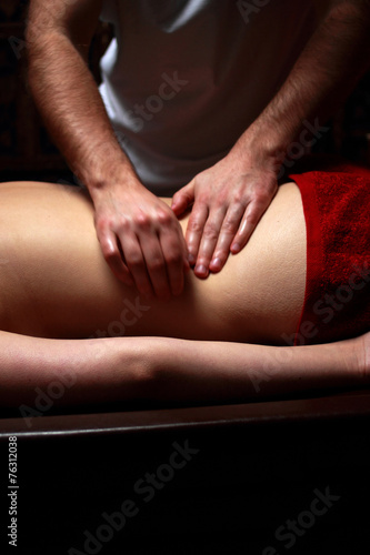 Beautiful young woman getting back massage at spa