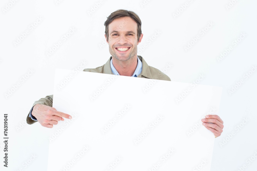 Happy delivery man pointing at blank billboard Happy delivery man pointing at blank billboard