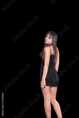 Teen cute girl in a black dress over black background