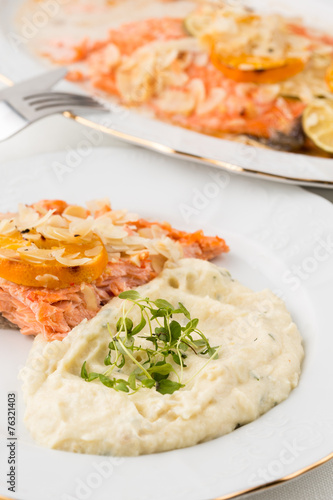 closeup of mashed potatoes with green leafs and salmon