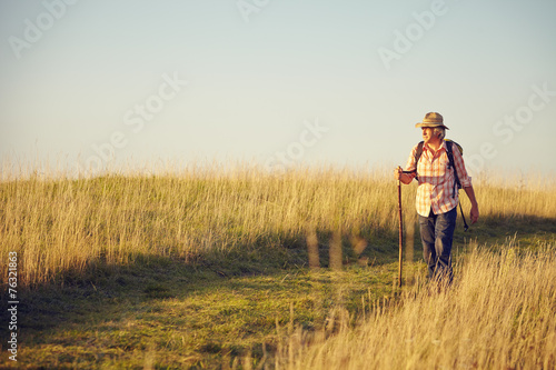 Mann auf Wiesenweg mit Stock © upixa