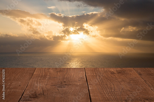 Wood flooring with a view of the sunset over the sea © strannik_fox