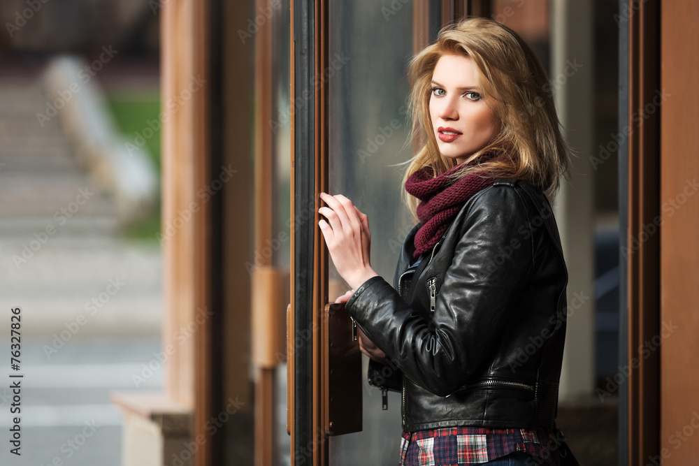 Young fashion blond woman in leather jacket at the mall door Young fashion blond woman in leather jacket at the mall door