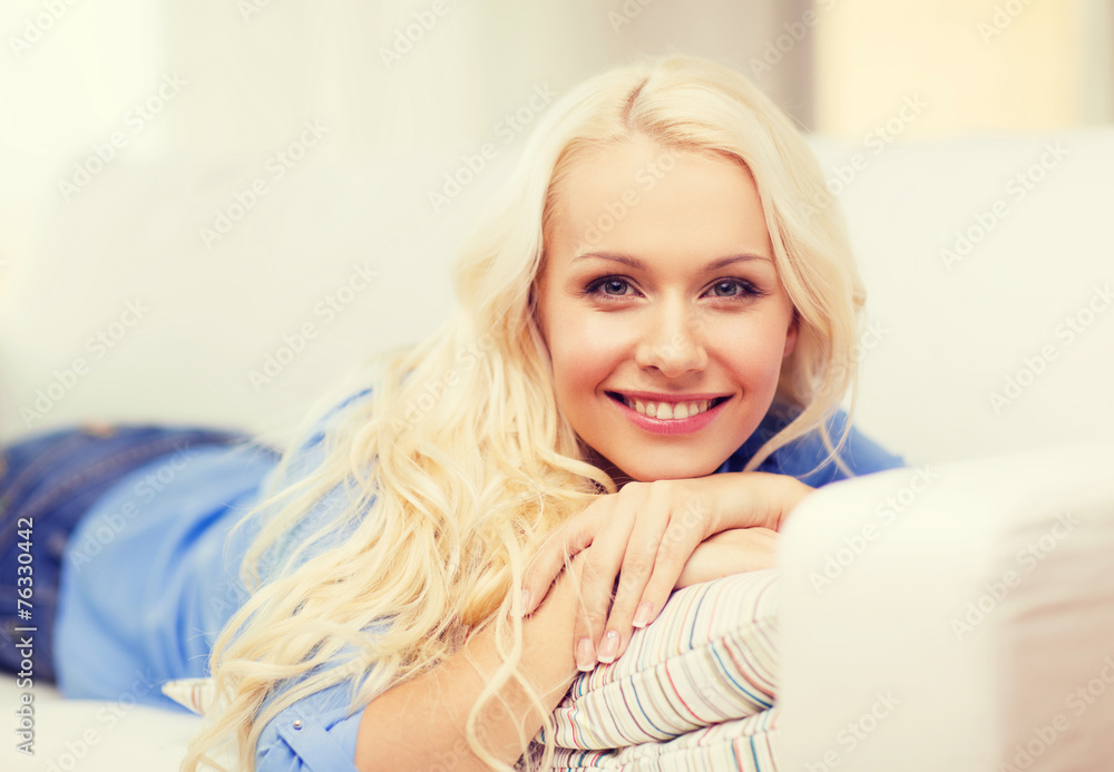 smiling young woman lying on sofa at home smiling young woman lying on sofa at home