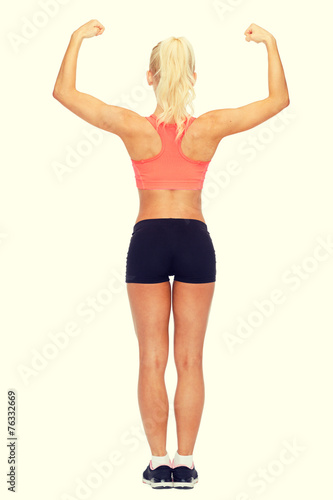 sporty woman from the back flexing her biceps