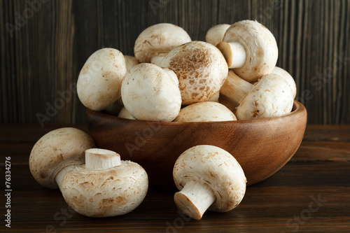 Mushrooms in a wooden bowl on wood