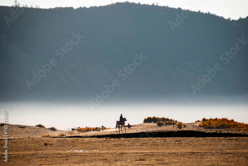 Horse rider at volcanic plateau of miunt Bromo, Indonesia photo