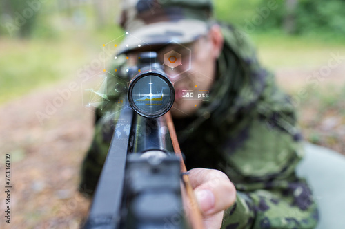 close up of soldier or sniper with gun in forest photo