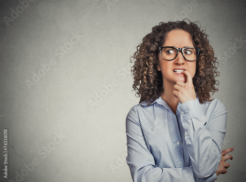 woman with glasses biting her fingernails craving for something