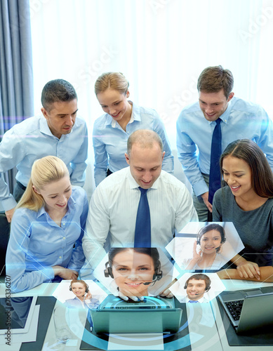 smiling business people with laptop in office © Syda Productions