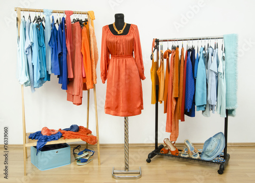 Wardrobe with complementary colors orange and blue clothes.