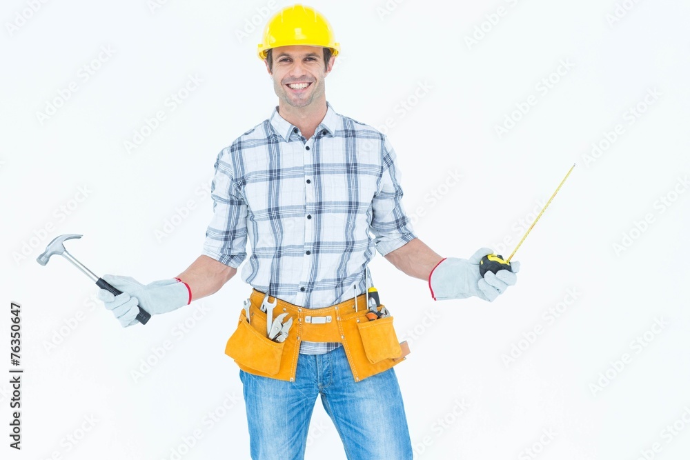 Technician holding hammer and measure tape Technician holding hammer and measure tape