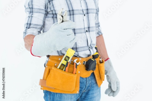 Technician with tool belt around waist holding pliers © WavebreakmediaMicro