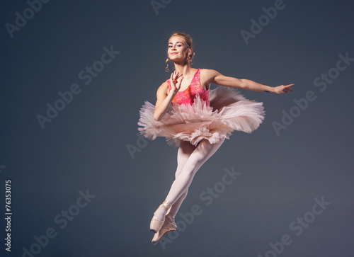 Beautiful female ballet dancer on a grey background. Ballerina