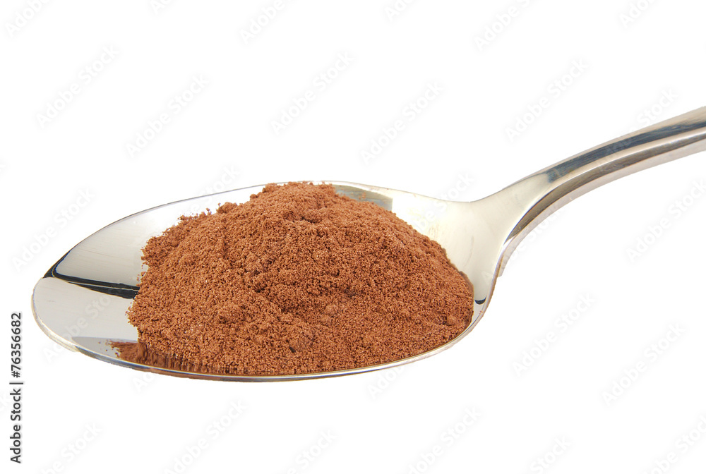 Cocoa powder in a metal spoon isolated on white background. Cocoa powder in a metal spoon isolated on white background.