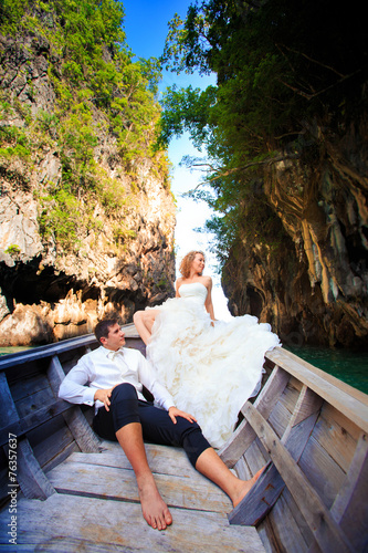 Obraz na plátně blonde bride and handsome groom on boat