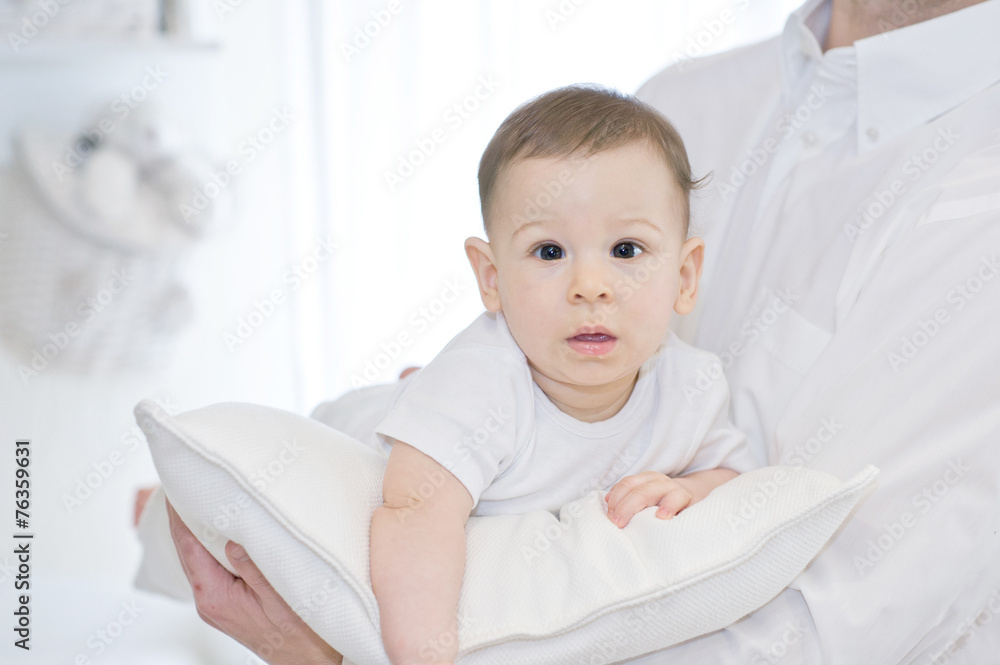 Portrait of a father with his lovely baby boy on white pillow Portrait of a father with his lovely baby boy on white pillow