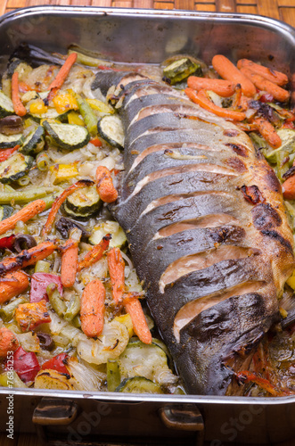 metal dish with baked fish and vegetables