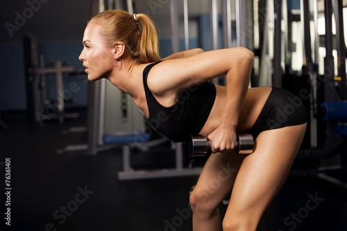 Athletic young lady doing workout with weights