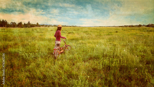 Hipster girl walking with bicycle in summer, vintage image
