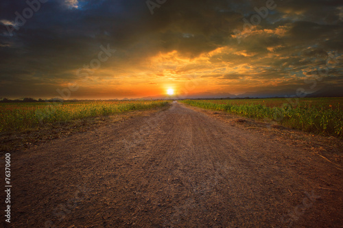 Φωτογραφία beautiful land scape of dusty road perspective to sun set sky wi