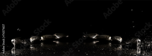 Spa background with wet basalt massage stones with water droplet