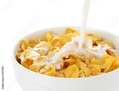 pouring milk into cornflakes bowl isolated on white