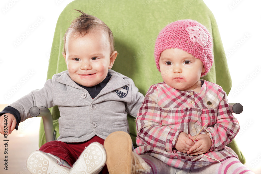 two sweet babies sitting on a green towel two sweet babies sitting on a green towel