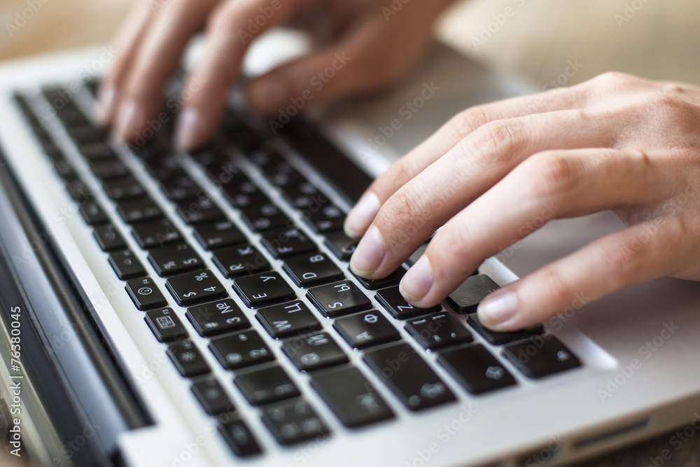 Women's fingers typing on laptop keyboard. Women's fingers typing on laptop keyboard.