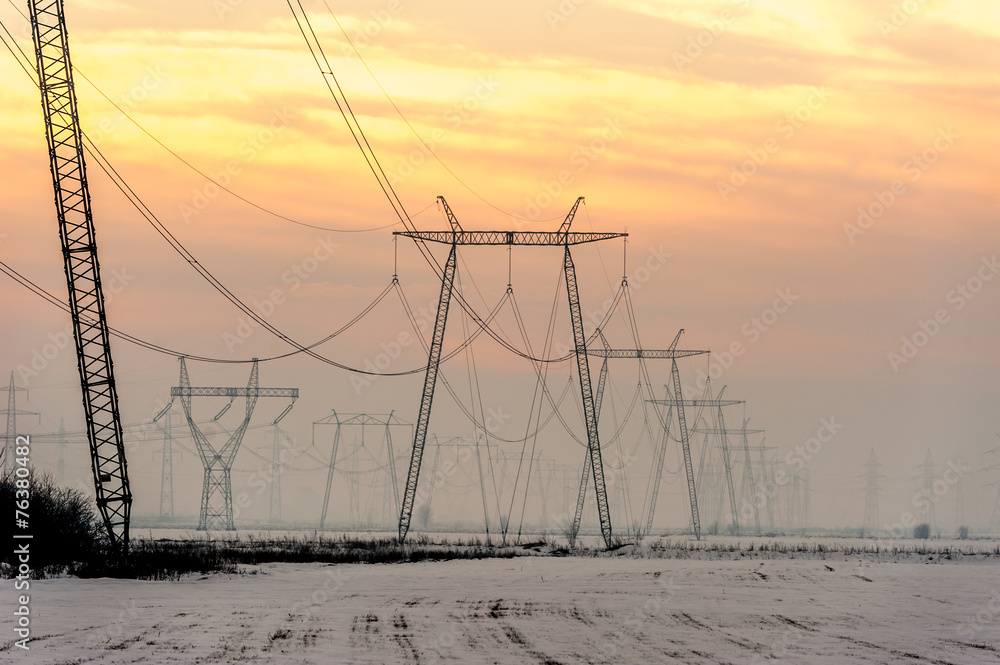 High-voltage power transmission towers in sunset