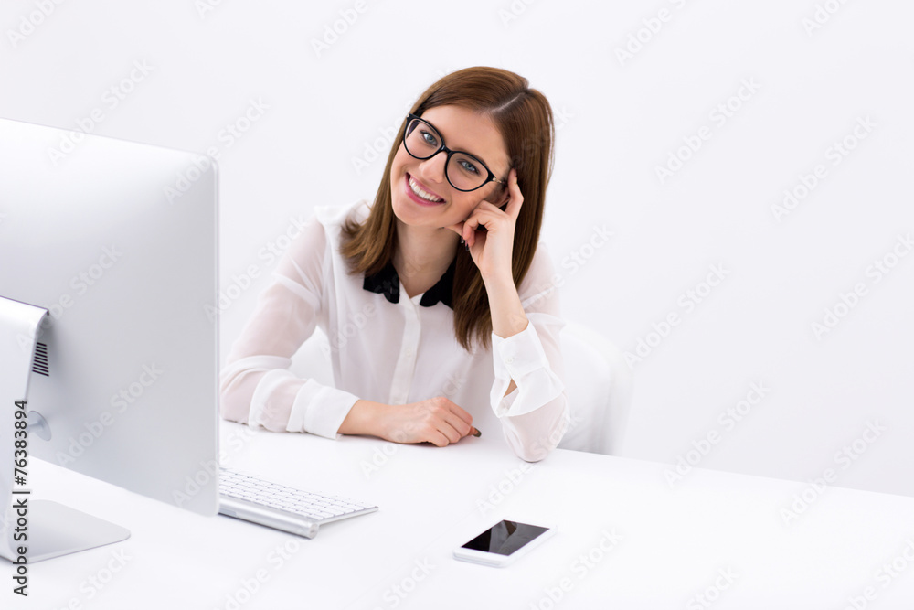 Happy businesswoman sitting at her worplace in office Happy businesswoman sitting at her worplace in office