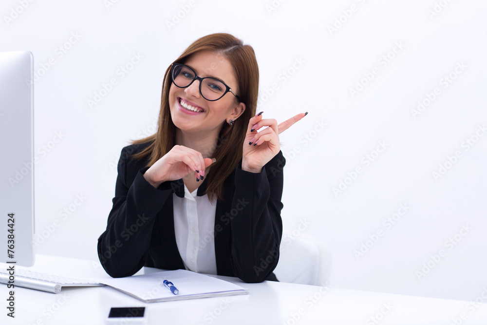 Young smiling businesswoman sitting at her workplace in office