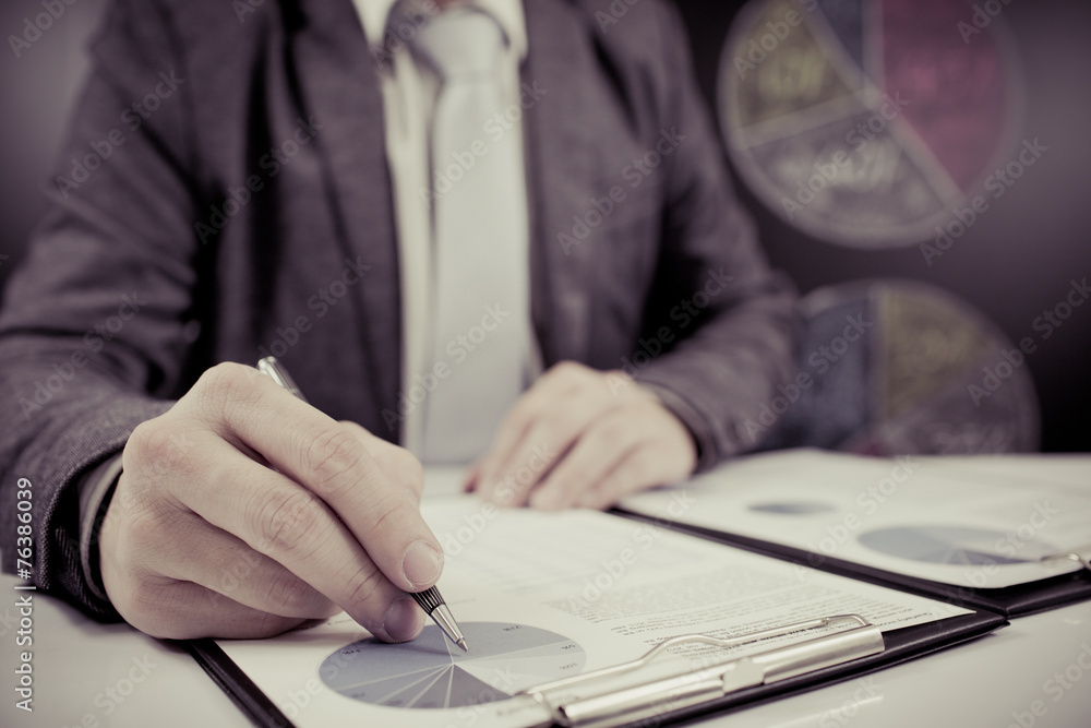 man hand with pen and business report man hand with pen and business report