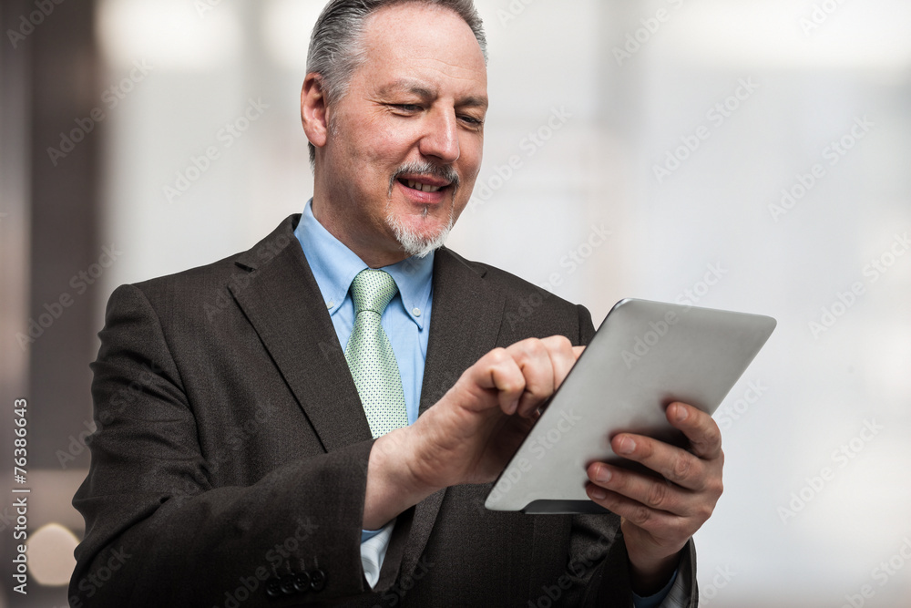 Smiling man using his tablet computer Smiling man using his tablet computer