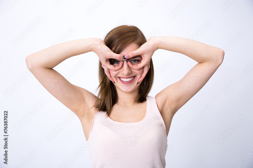 Young happy woman looking through a hole in her fingers Young happy woman looking through a hole in her fingers