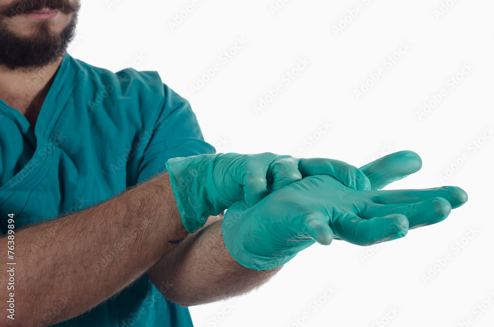 Young surgeon wearing gloves for surgery Young surgeon wearing gloves for surgery