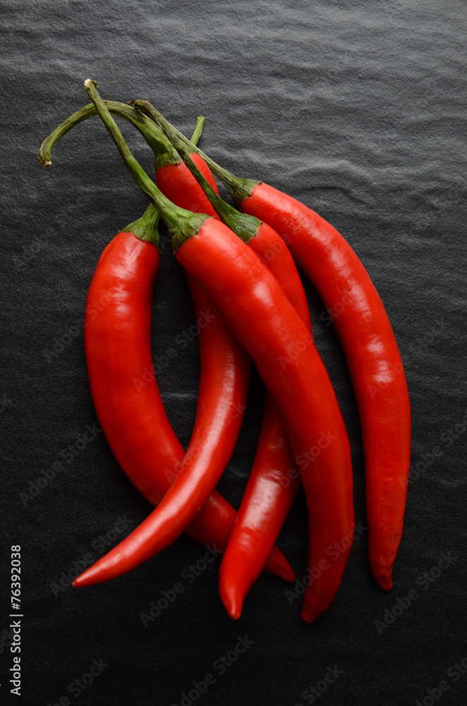 Red hot chili peppers on a dark, stone background