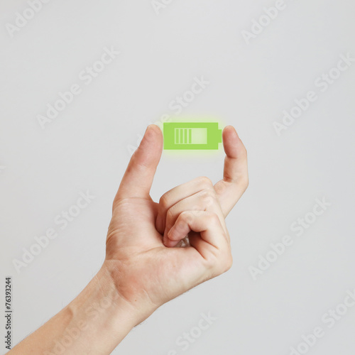 Male hand holding green battery  - power concept