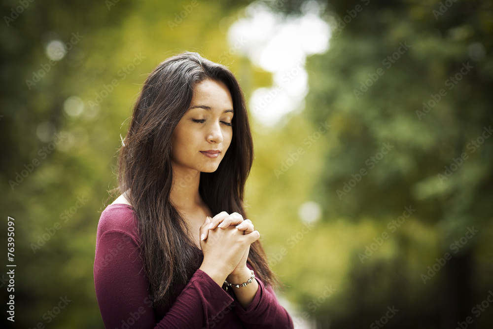Woman praying outdoors - obrazy, fototapety, plakaty 