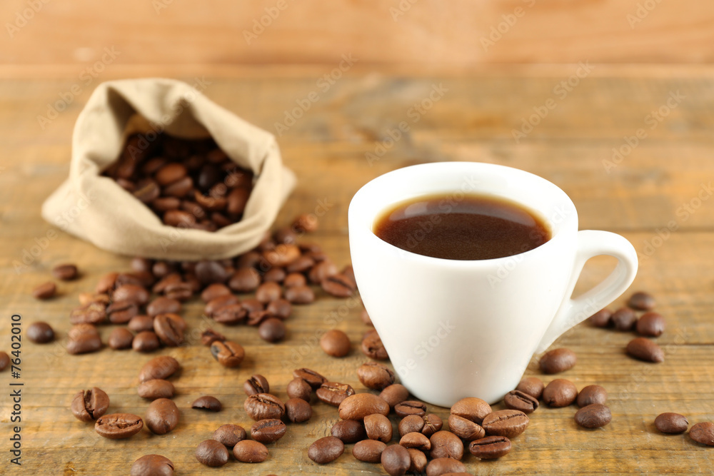 Cup of coffee with beans on rustic wooden background Cup of coffee with beans on rustic wooden background