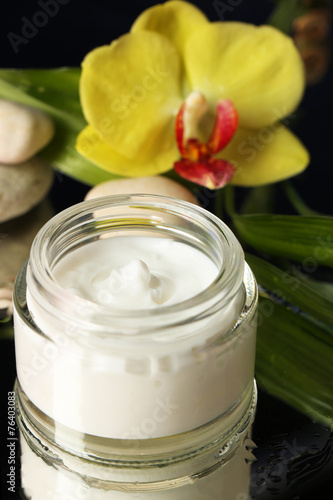 Fototapeta Naklejka Na Ścianę i Meble -  Face cream with orchid flower on dark background