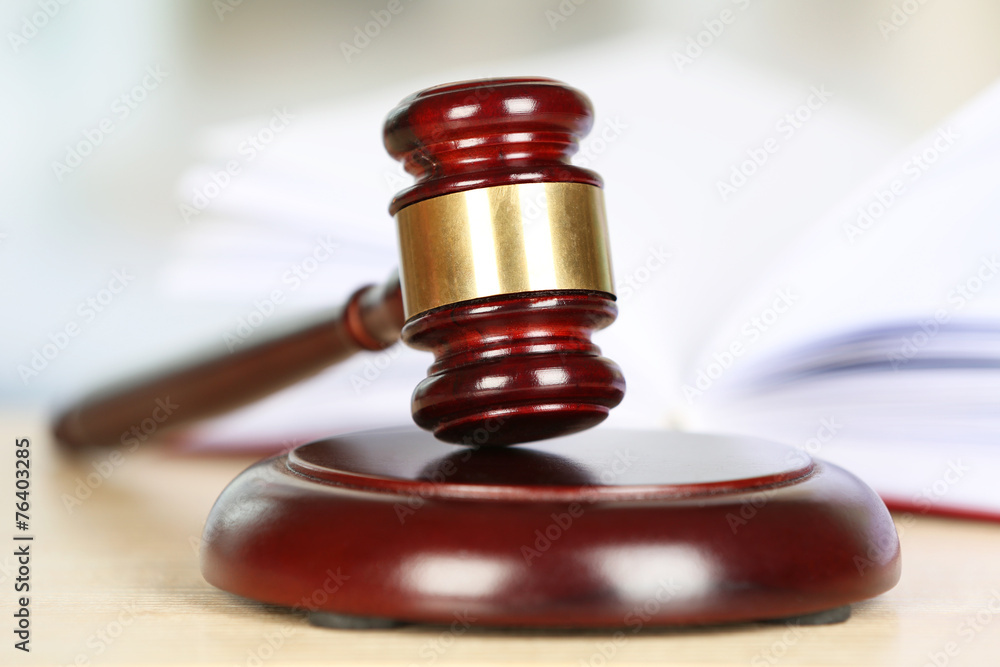 Wooden judges gavel on wooden table, close up