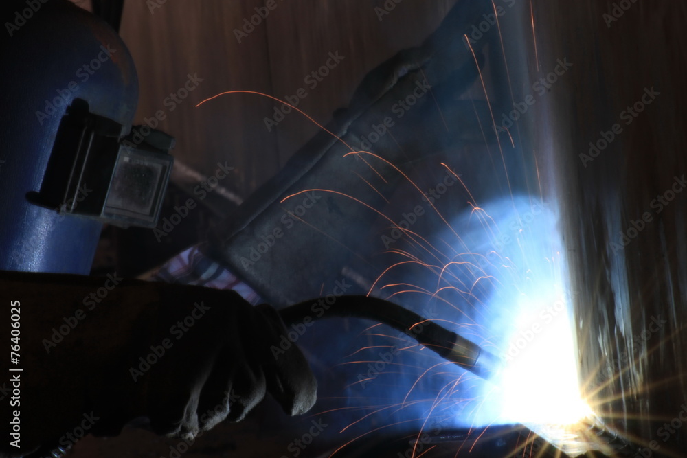Industrial arc welder working in factory Industrial arc welder working in factory