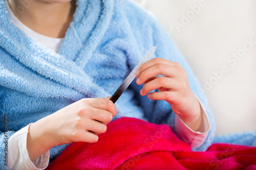 Teenager with towel on her head polishing fingernails