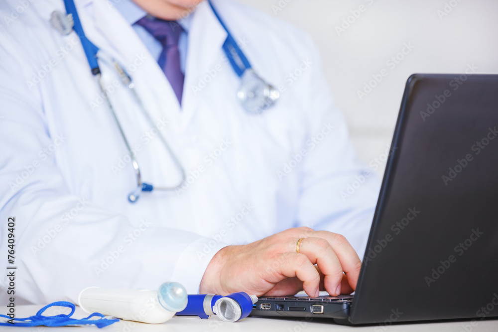 Doctor in white coat using laptop. Doctor in white coat using laptop.