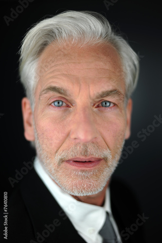 Portrait eines grauhaarigen Mannes mit stahlblauen Augen  photo